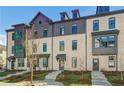 Exterior shot of townhomes showing neutral brick, black trim, and lush landscaping adding charm at 608 Marimba Pike, Mcdonough, GA 30253