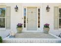 Inviting front entrance featuring a stylish sage-colored door framed by sidelights and potted flowers at 1260 Centenary Rdg, Snellville, GA 30078