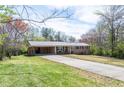 A single-story brick home boasting a carport, spacious front yard, and long driveway at 6348 Garnet Dr, Douglasville, GA 30135