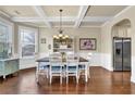 Formal dining room featuring hardwood floors, wainscoting, coffered ceiling, modern chandelier, and stainless steel refrigerator at 4315 Balsam Bark Dr, Cumming, GA 30028