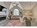 Cozy living room featuring a fireplace, vaulted ceilings, and ample natural light, perfect for relaxation at 7040 Shady Oak Ln, Cumming, GA 30040