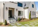 Charming home entrance with a stone walkway, well-kept lawn, manicured landscaping, and decorative outdoor lighting at 312 Meadow Dr, Alpharetta, GA 30009