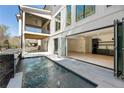 Stunning outdoor space featuring a pool, outdoor kitchen, and access to the home's modern interior through folding glass doors at 312 Meadow Dr, Alpharetta, GA 30009