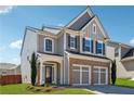 Beautiful two-story home with gray siding, brick accents, and a well-maintained front lawn on a sunny day at 6015 Crestwick Way, Cumming, GA 30040