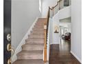 Inviting home foyer with carpeted stairs, hardwood floors, and view into an open living space at 6015 Crestwick Way, Cumming, GA 30040