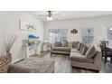 Cozy living room with gray sectional sofa, modern TV, ceiling fan, and hardwood floors at 1901 Creel Ln, Atlanta, GA 30349