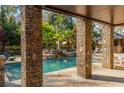 Covered outdoor living space overlooking a backyard pool and landscaped garden, providing a serene setting at 2461 Oak Grove Ne Ests, Atlanta, GA 30345
