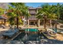 Backyard oasis with a multi-tiered pool, tropical palms, and a cozy cabana area at 2461 Oak Grove Ne Ests, Atlanta, GA 30345