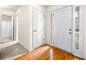Bright foyer features gleaming hardwood floors, a stylish white door, and a glimpse of the bathroom at 57 Sorghum Ct, Dallas, GA 30157
