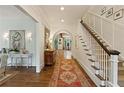 Elegant entryway featuring hardwood floors, staircase, and an arched doorway leading to the dining room at 891 Glenbrook Nw Dr, Atlanta, GA 30318