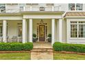 Close-up of the home's entrance featuring a covered porch, stone pathway, and manicured landscaping at 891 Glenbrook Nw Dr, Atlanta, GA 30318