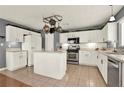 Well-equipped kitchen with white cabinetry, stainless steel appliances, an island and tiled floors at 411 Sureyya Dr, Canton, GA 30114