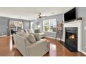 Comfortable living room with a fireplace, hardwood floors, and large windows offering ample natural light at 411 Sureyya Dr, Canton, GA 30114