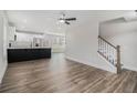 Bright living area featuring hardwood floors, a ceiling fan, staircase, and view of the kitchen and dining area at 6355 Akins Way, Cumming, GA 30041