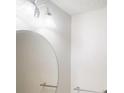 Clean bathroom featuring a large round mirror and simple, elegant fixtures at 3515 Devon Chase Rd, Atlanta, GA 30349
