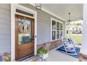 Inviting front porch with rocking chairs, decorative wreath, and patriotic accents on a blue rug at 1788 Hanover West Ct, Lawrenceville, GA 30043