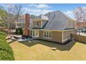 Spacious backyard featuring a patio with outdoor seating, lush lawn, and mature trees, perfect for entertaining at 548 Lawton Bridge Sw Rd, Smyrna, GA 30082