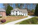 Elegant home showcasing a well-maintained lawn, a curved driveway, and mature trees at 2376 Massey Ln, Decatur, GA 30033