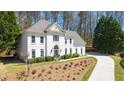 Front view of an elegant white home with manicured front yard and a curved driveway at 2376 Massey Ln, Decatur, GA 30033