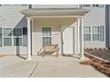 Inviting front porch featuring white columns, new front door, and a wooden bench at 258 Venture Path, Hiram, GA 30141