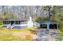 Quaint house with a cozy screened-in porch and detached two-car garage nestled among the trees at 528 Lower Scott Mill Rd, Canton, GA 30114