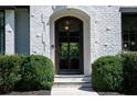 Elegant arched front door with black frame and textured white brick facade at 5495 Mount Vernon Pkwy, Atlanta, GA 30327