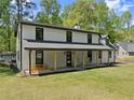 Expansive home featuring a covered porch with rocking chairs, an inviting space to relax outdoors at 110 Myers Dr, Alpharetta, GA 30009