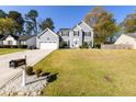 Two-story home with an attached garage and a well-manicured front lawn on a clear day at 302 Cimarron Way, Lawrenceville, GA 30044