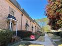 Beautiful row of brick townhomes with manicured landscaping, creating a charming neighborhood street view at 6980 Roswell Rd # E1, Atlanta, GA 30328