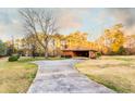 Long driveway leading to a well-maintained brick house, surrounded by mature trees and a spacious yard at 3856 Egypt Rd, Snellville, GA 30039