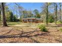 Traditional brick home featuring a covered entryway, symmetrical design, and a spacious, tree-lined front yard at 6339 Cornelia Dr, Douglasville, GA 30134