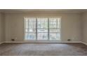 Spacious living room with large windows and carpet flooring, offering lots of natural light at 3637 Windmill Rd, Ellenwood, GA 30294