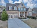 Charming two-story brick home featuring a welcoming front porch and a well-manicured lawn at 4916 Locklear Way, Marietta, GA 30066