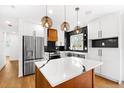Modern kitchen with white cabinetry, stainless steel appliances, quartz countertops, and stylish pendant lighting at 6660 Hidden Brook Trl, Atlanta, GA 30349