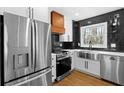 Updated kitchen featuring stainless steel appliances, a black tiled backsplash, and white shaker cabinets at 6660 Hidden Brook Trl, Atlanta, GA 30349
