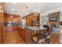 Open kitchen with wood cabinets, a central island, stone countertops, and hardwood floors at 2160 Bradley Trl, Cumming, GA 30041