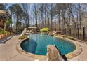 Private in-ground pool with stone accents, waterfall feature, and lounge area at 2160 Bradley Trl, Cumming, GA 30041