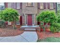 Close-up of the front door with decorative landscaping and a brick walkway at 3253 Brookshire Way, Duluth, GA 30096