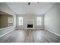 Bright living room with a painted brick fireplace and a large window at 228 Roberts Trl, Locust Grove, GA 30248