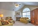 A cozy living room featuring a fireplace, vaulted ceiling, and abundant natural light at 2730 Vintage Reserve Ln, Marietta, GA 30066