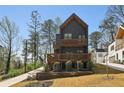 Modern two-story home featuring a dark exterior, wooden balconies, and well-kept landscaping at 1792 Charles Nw Pl, Atlanta, GA 30318