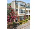 Inviting townhouse showcasing a beautifully landscaped front and multi-level facade with a flowering tree at 223 Riverstone Commons Cir, Canton, GA 30114