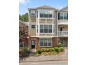 Inviting townhouse showcasing a beautifully landscaped front and multi-level facade with a flowering tree at 223 Riverstone Commons Cir, Canton, GA 30114