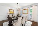Formal dining room featuring modern decor, a chandelier, and a bright window, perfect for Gathering meals at 4720 Timberland Sw Dr, Mableton, GA 30126