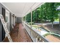 Spacious covered front porch with brick flooring and views of the landscaped yard and surrounding trees at 4720 Timberland Sw Dr, Mableton, GA 30126