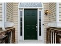 Elegant dark green front door with sidelights and a transom window, framed by white trim and siding at 522 Bass Nw Pointe, Kennesaw, GA 30144