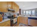 Functional kitchen with stainless steel appliances, wood cabinets, and bright, sunny windows at 962 Cove Lake Ct, Lawrenceville, GA 30045