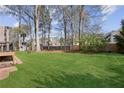 Spacious backyard with lush green grass, mature trees, privacy fence and storage shed at 321 Covered Bridge Sw Pl, Smyrna, GA 30082