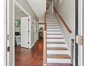 Welcoming foyer featuring hardwood floors and a staircase with wood banister at 8470 Wallace Tatum Rd, Cumming, GA 30028