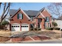 Beautiful brick home with a two-car garage, brick driveway and lush landscaping at 1107 Carroll Ct, Norcross, GA 30071
